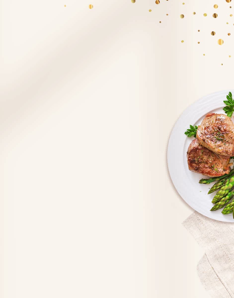 ButcherBox gift box with plates of pork chops and bacon on a cream linen napkin with confetti